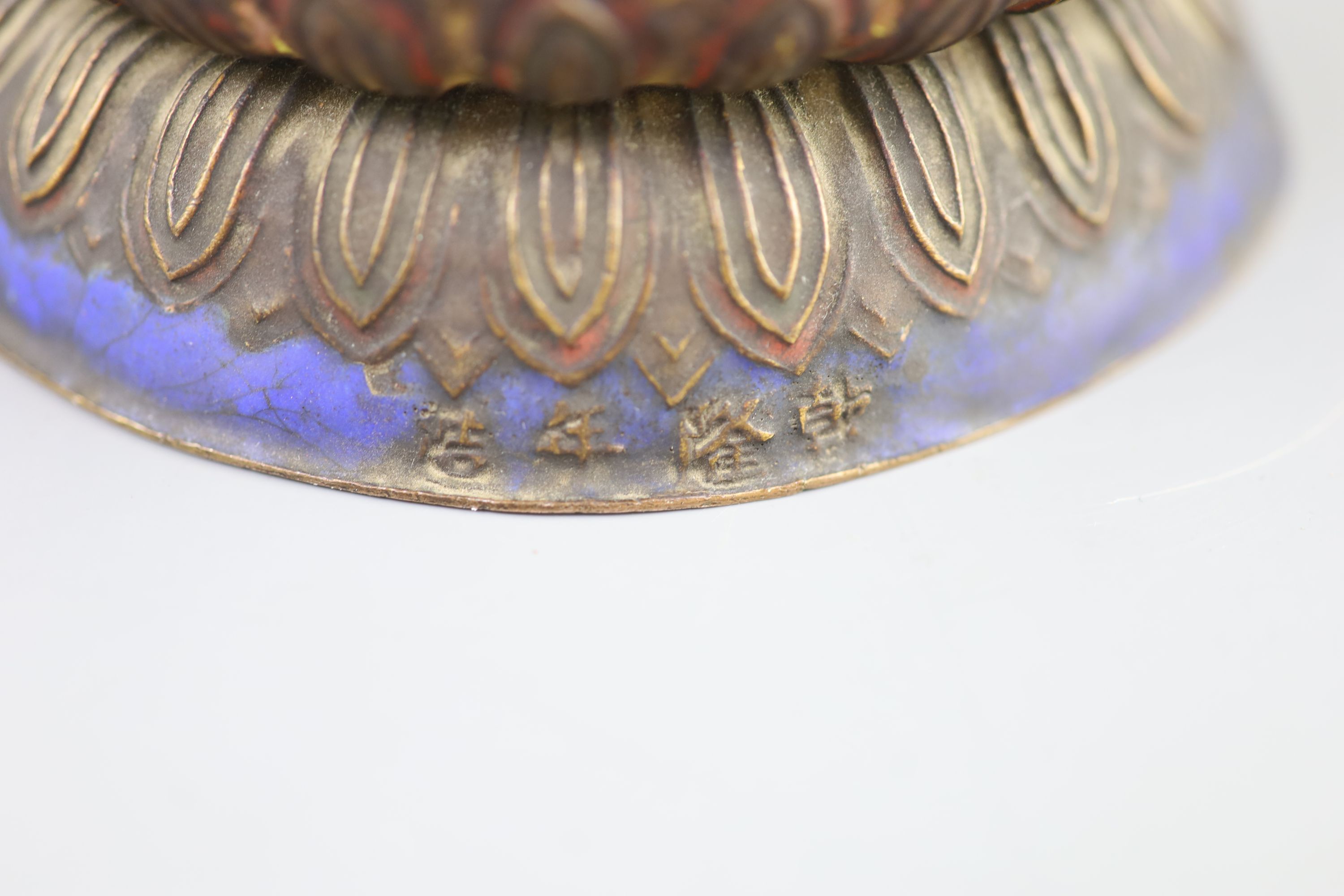 A Chinese copper alloy and enamel seated figure of Buddha Shakyamuni, Qing dynasty, 24cm high, faults